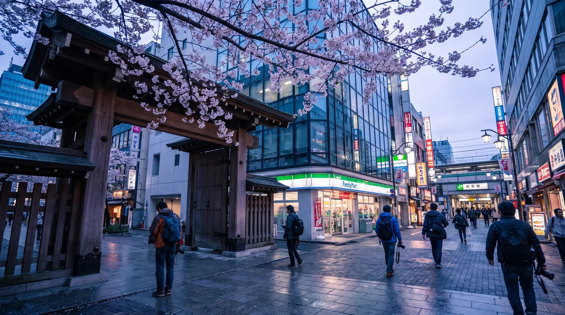 Night view of Shinjuku station with neon signs, convenience store shelves, and a buffet table with Japanese dishes.